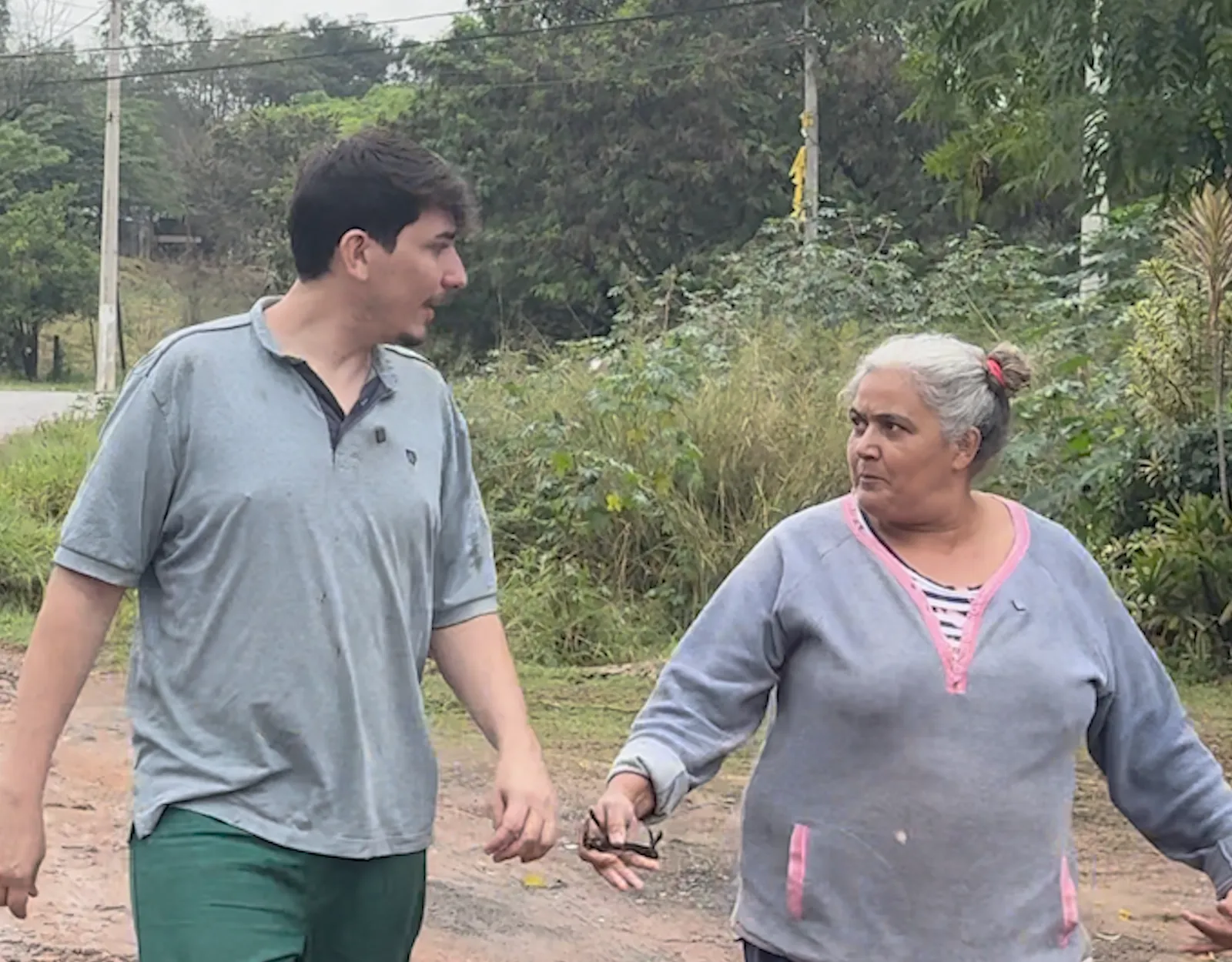 Caio e Luzia caminhando pela estrada de terra que leva ao lixão